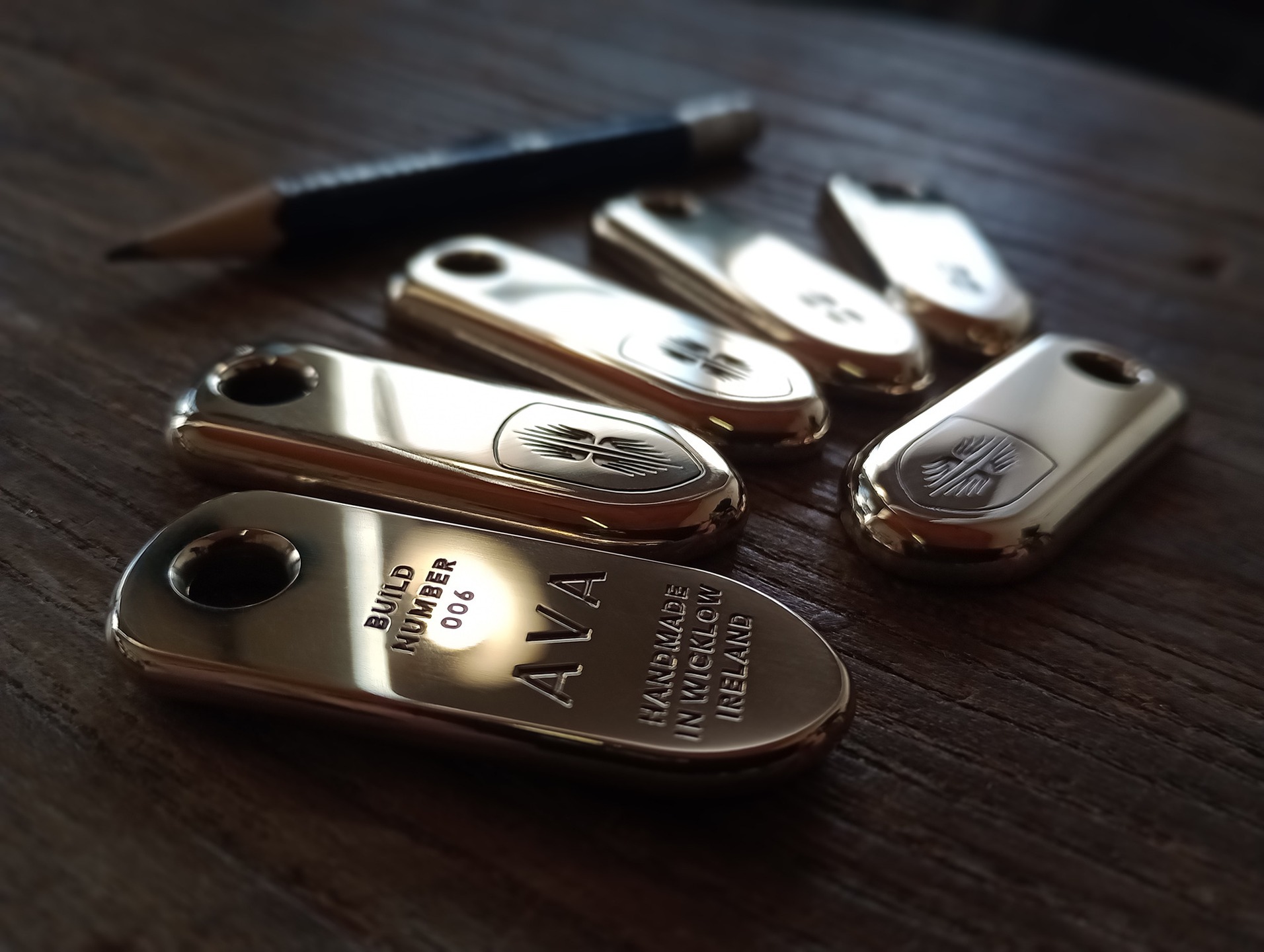 A set of six bespoke and individually numbered brass key-fobs and a hood badge made for www.studioava.com