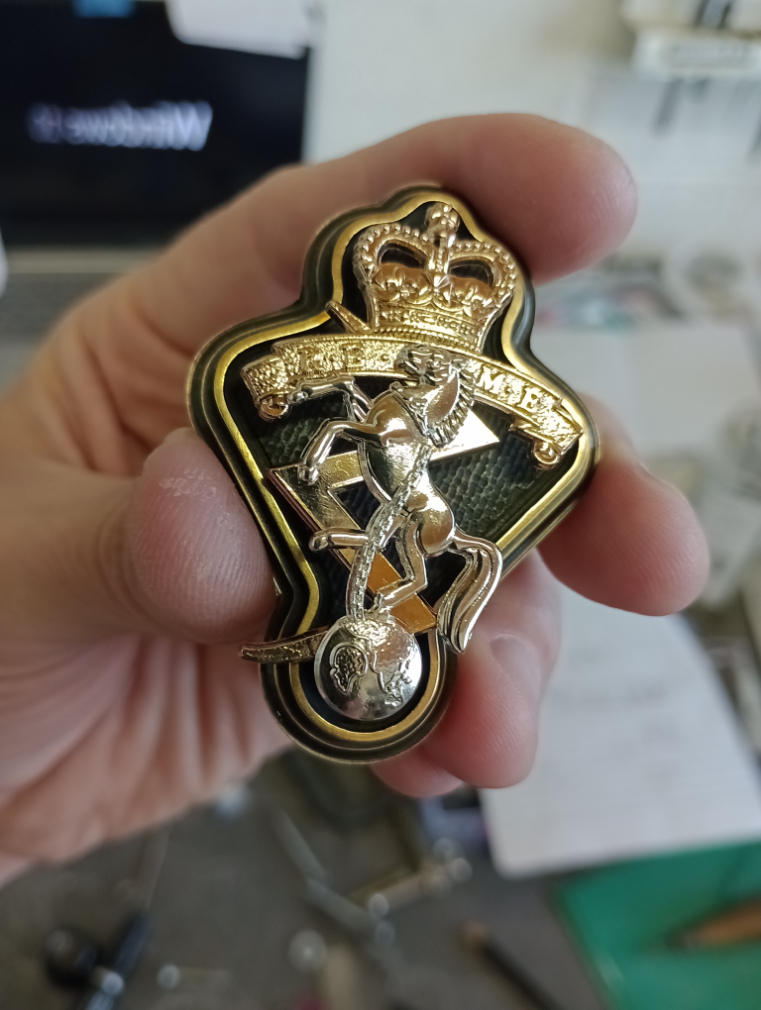 REME cap badge on a copper back-plate