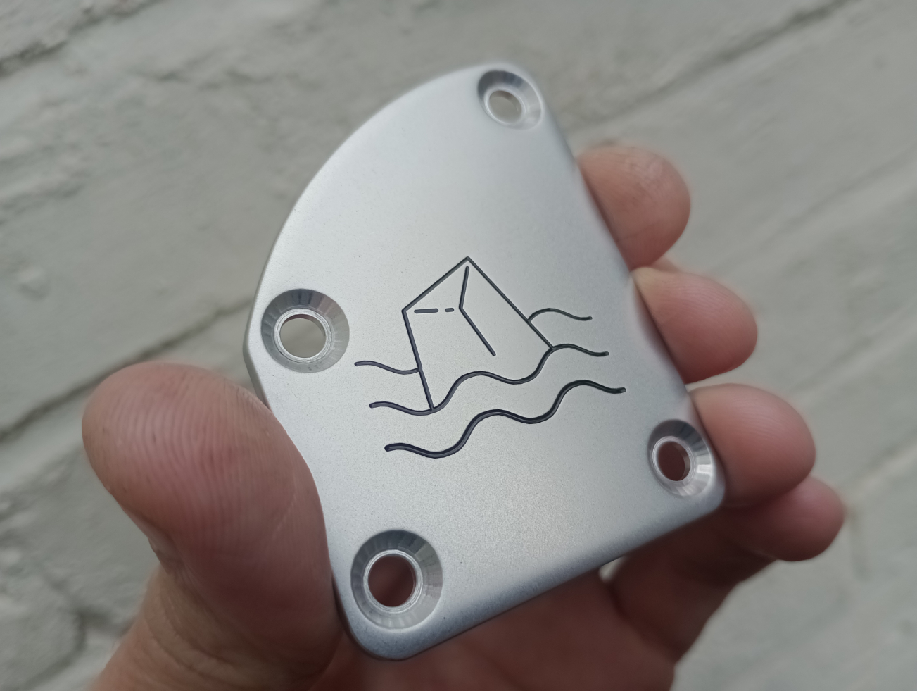 A custom engraved and resin-filled neck-plate, matte tumble finish