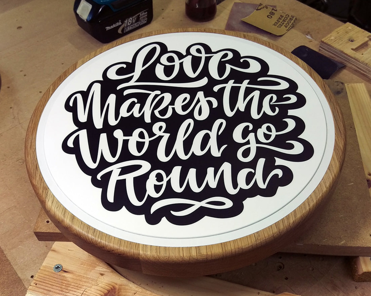 An oak and resin cake stand.  The lettering is carved and resin filled across several stages.