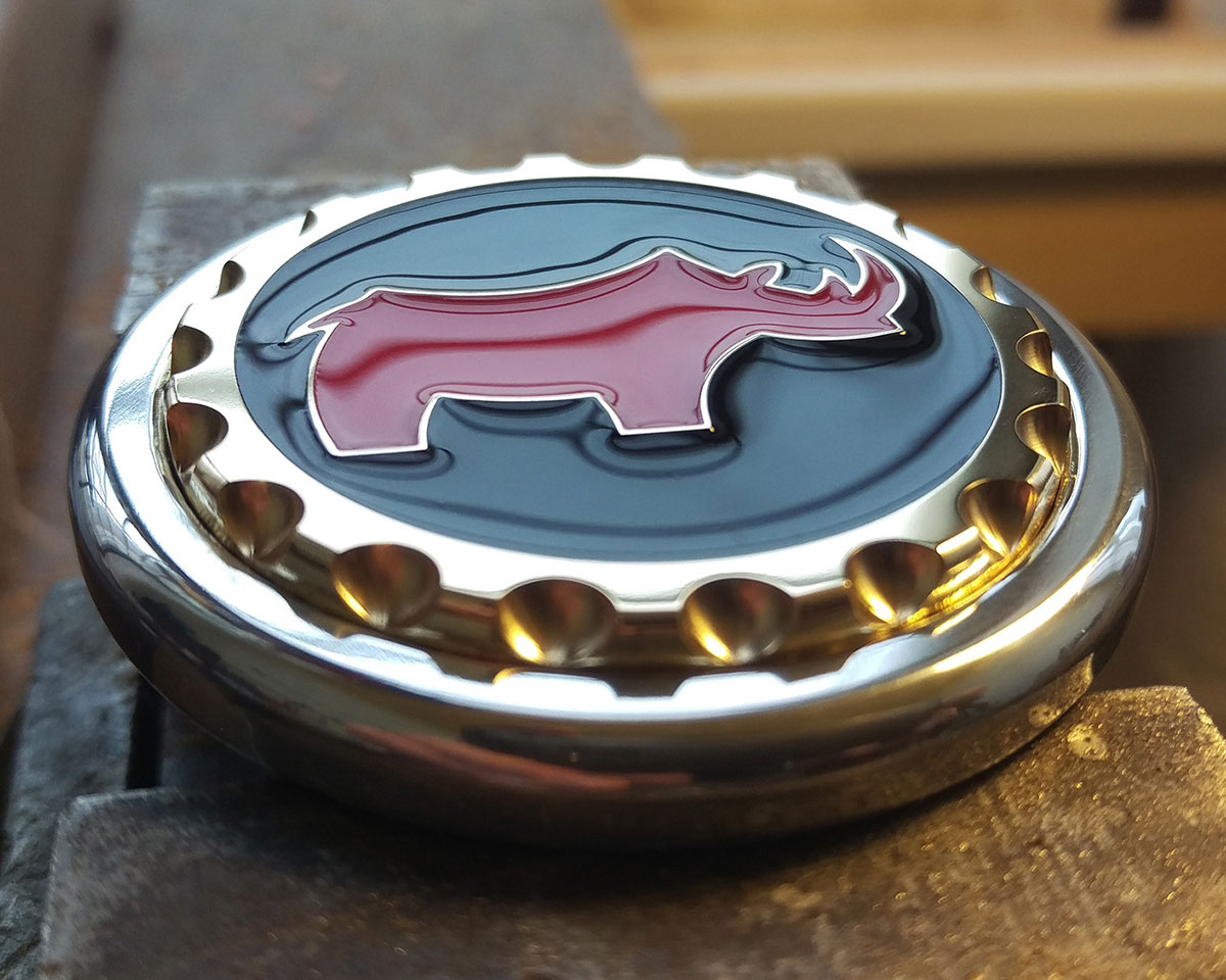 A golf marker customised with a client's logo, made using aluminium, brass and resin.